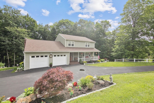 view of front of home with a garage, covered porch, and a front lawn