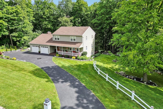 view of front facade featuring a garage, a front yard, and a porch