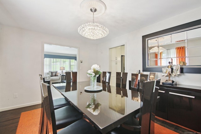 dining space with dark wood-type flooring and a notable chandelier