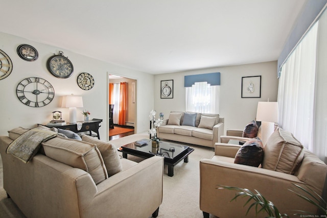 carpeted living room featuring a baseboard heating unit