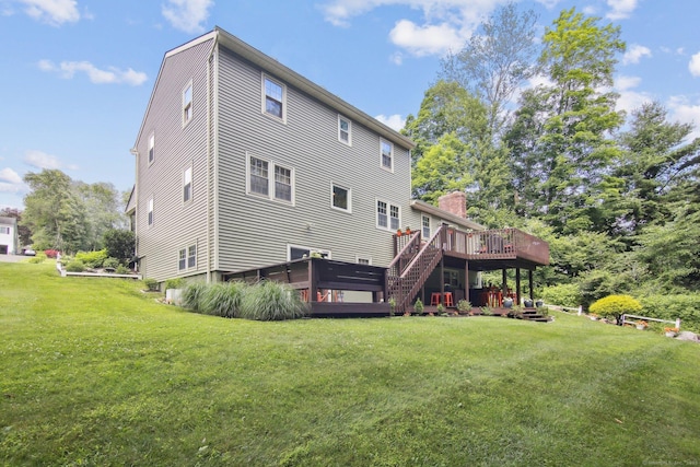 rear view of house featuring a yard and a deck