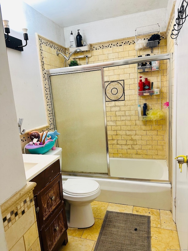 full bathroom featuring tile patterned flooring, vanity, toilet, and shower / bath combination with glass door