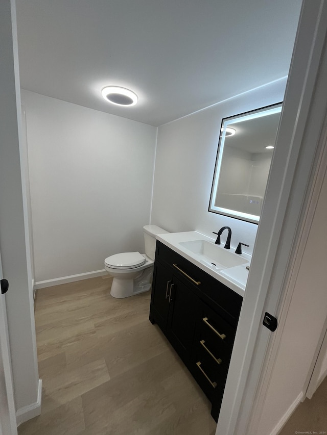 bathroom featuring hardwood / wood-style floors, vanity, and toilet