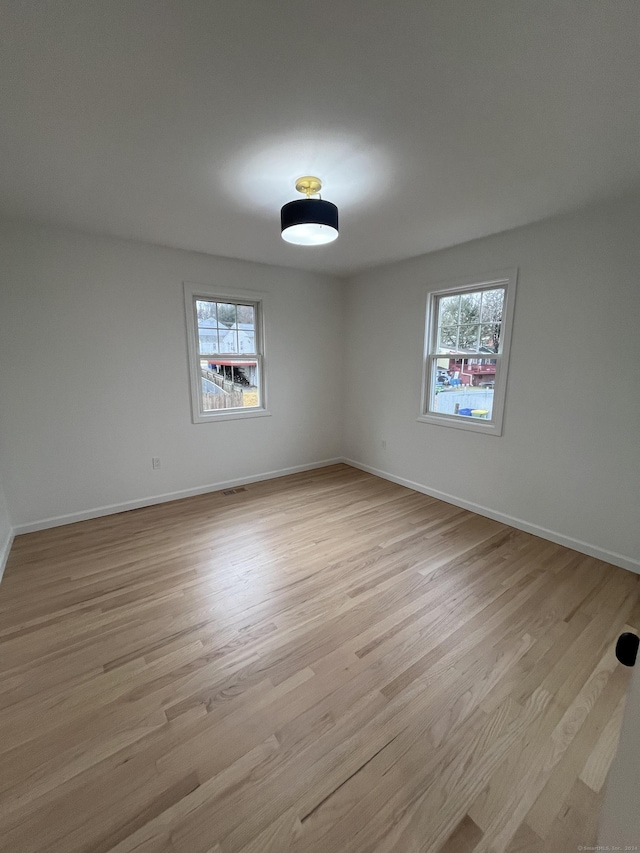 unfurnished room featuring plenty of natural light and light hardwood / wood-style flooring