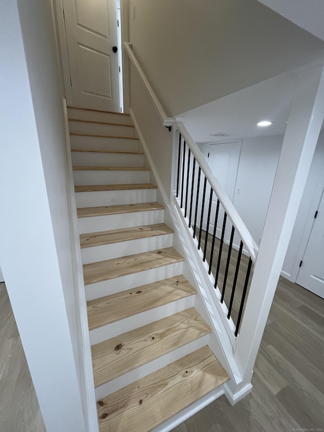 stairway with hardwood / wood-style flooring