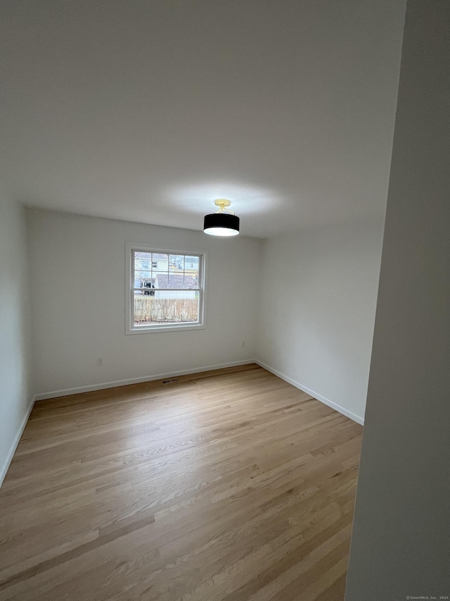 empty room with light hardwood / wood-style flooring