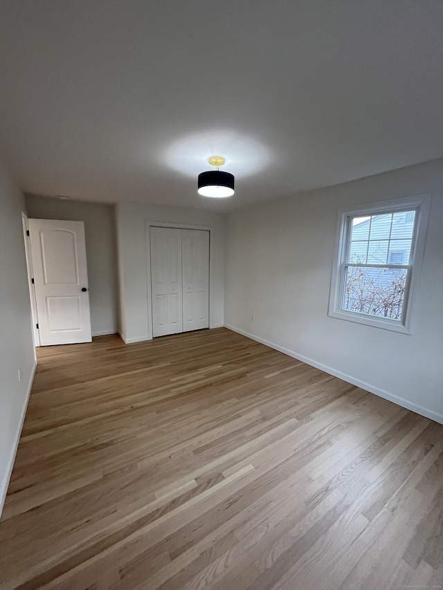 unfurnished bedroom featuring a closet and light hardwood / wood-style flooring