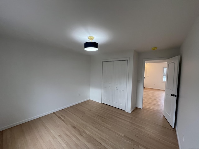 unfurnished bedroom featuring light hardwood / wood-style floors and a closet