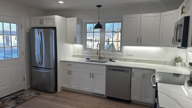 kitchen featuring hardwood / wood-style flooring, white cabinetry, sink, and appliances with stainless steel finishes