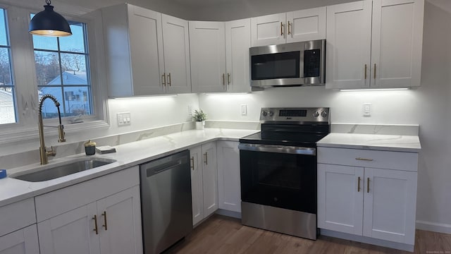 kitchen with dark hardwood / wood-style flooring, white cabinetry, sink, and appliances with stainless steel finishes