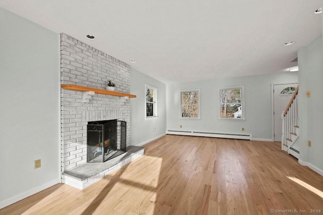 unfurnished living room with a fireplace, a baseboard radiator, and light hardwood / wood-style floors