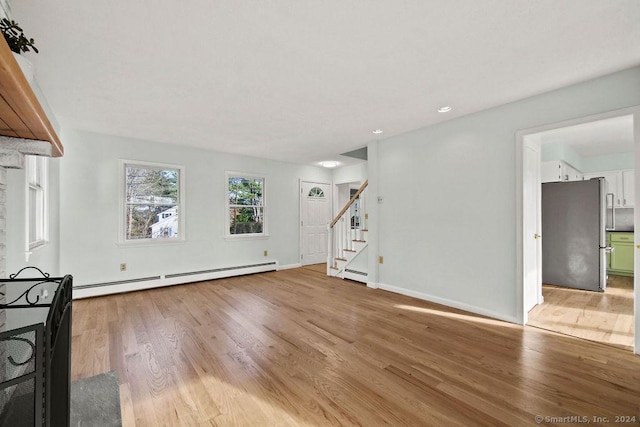 unfurnished living room with a baseboard radiator and light hardwood / wood-style floors