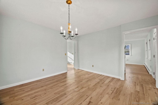 unfurnished dining area with a chandelier, light wood-type flooring, and a baseboard heating unit