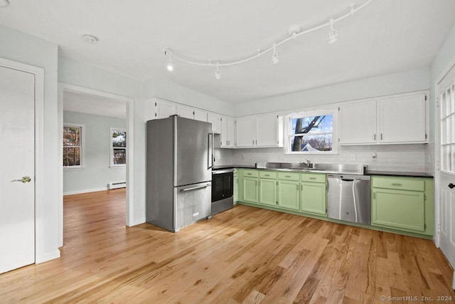 kitchen featuring green cabinetry, stainless steel appliances, sink, and a baseboard heating unit