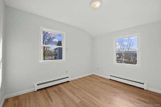 spare room with baseboard heating, plenty of natural light, and light hardwood / wood-style flooring