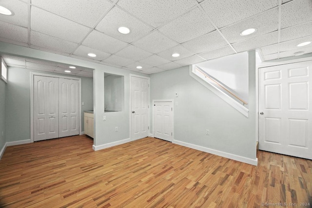 basement with hardwood / wood-style flooring and a drop ceiling