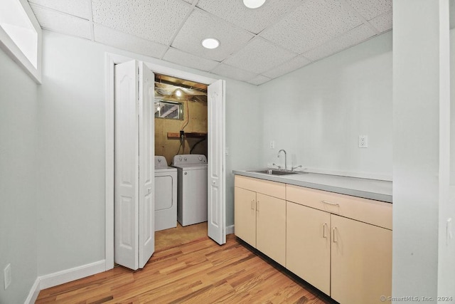 laundry room with sink, washing machine and clothes dryer, and light wood-type flooring