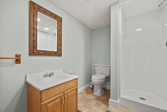 bathroom with vanity, a paneled ceiling, a shower, and toilet