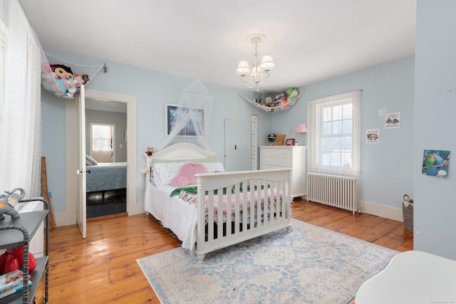 bedroom featuring wood-type flooring, radiator, and multiple windows