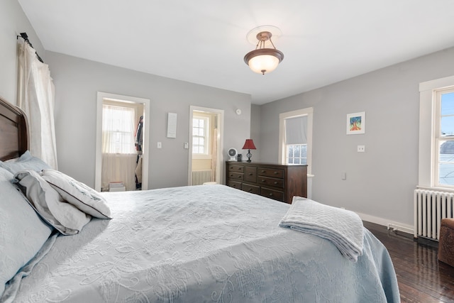 bedroom featuring ensuite bathroom, radiator heating unit, and dark wood-type flooring