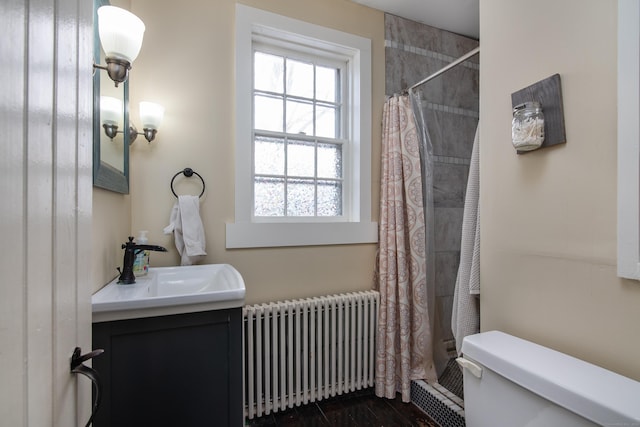 bathroom featuring radiator heating unit, vanity, a shower with shower curtain, and toilet