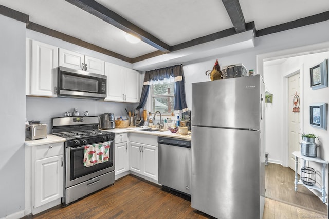 kitchen with white cabinets, sink, beamed ceiling, and appliances with stainless steel finishes