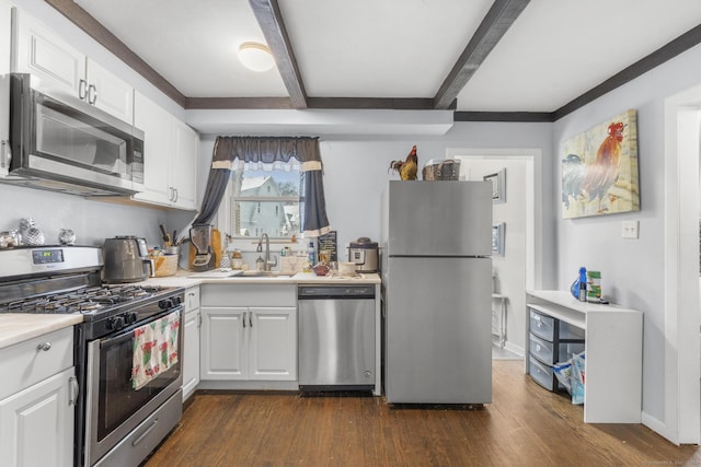 kitchen with dark hardwood / wood-style flooring, stainless steel appliances, sink, beam ceiling, and white cabinets