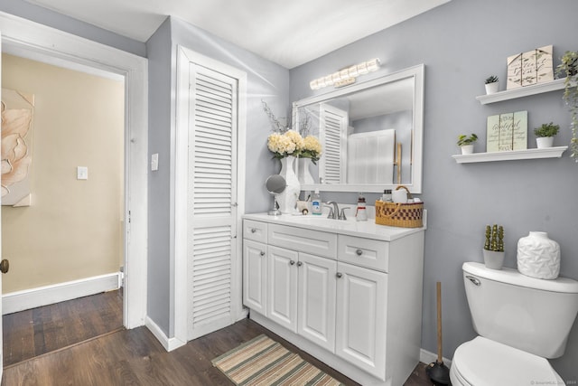 bathroom with hardwood / wood-style flooring, vanity, and toilet