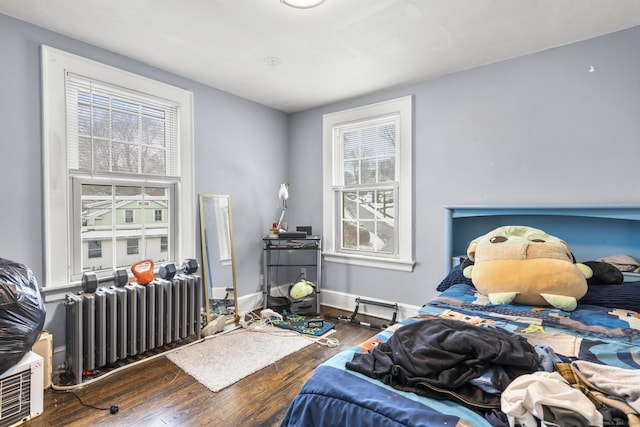 bedroom featuring radiator heating unit and dark hardwood / wood-style floors