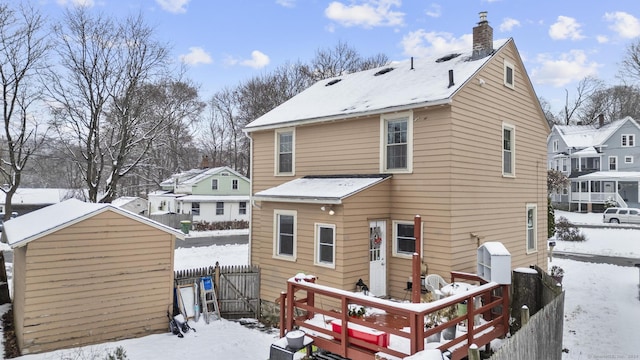 snow covered house with a storage shed