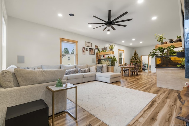 living room with light hardwood / wood-style flooring and ceiling fan