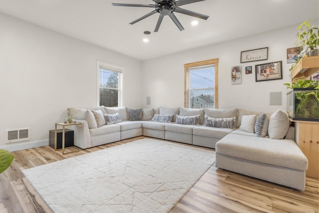 living room featuring ceiling fan and light hardwood / wood-style flooring