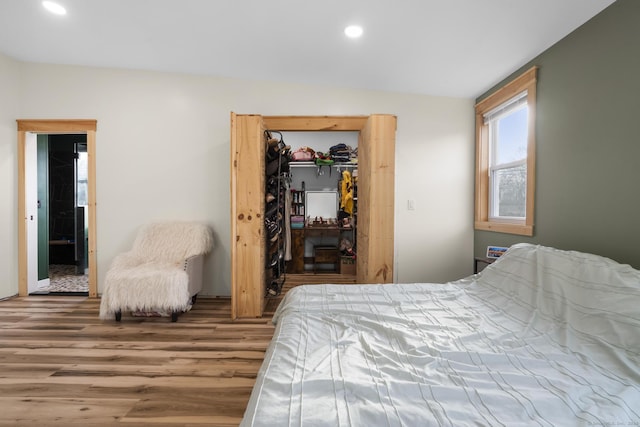 bedroom featuring lofted ceiling, wood-type flooring, and a closet