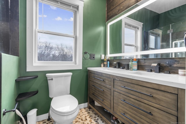 bathroom featuring a wealth of natural light, vanity, and toilet