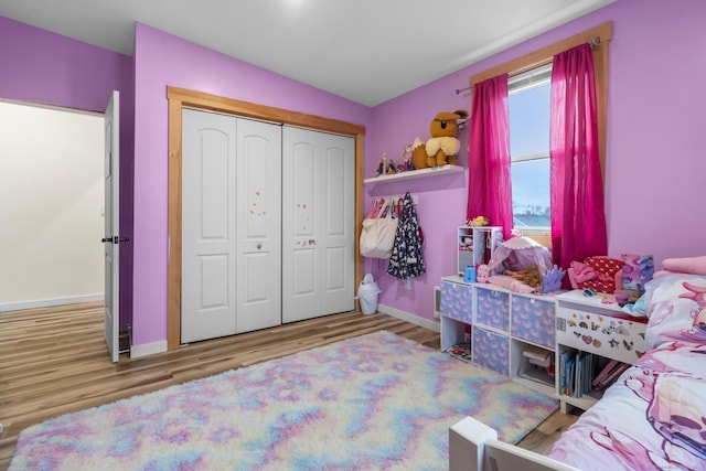 bedroom featuring hardwood / wood-style flooring, a closet, and lofted ceiling