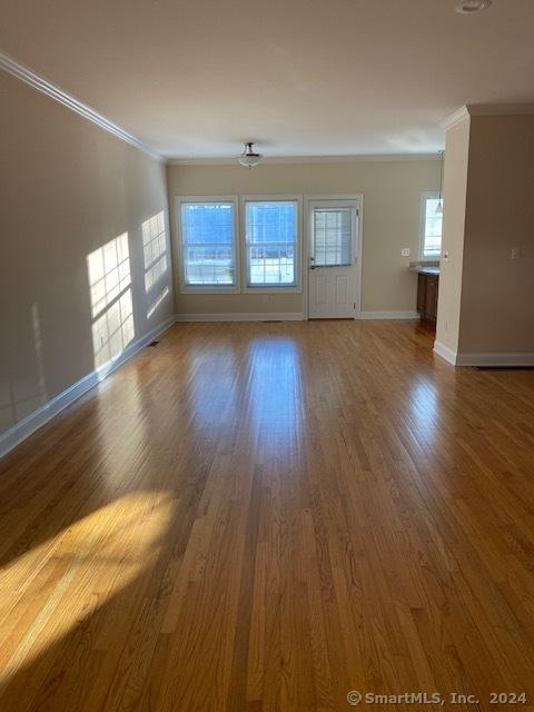 unfurnished room with ornamental molding and hardwood / wood-style flooring