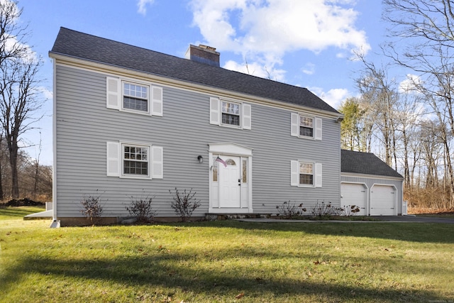 colonial house featuring a garage and a front lawn