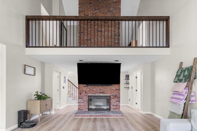 living room with light hardwood / wood-style floors and a brick fireplace