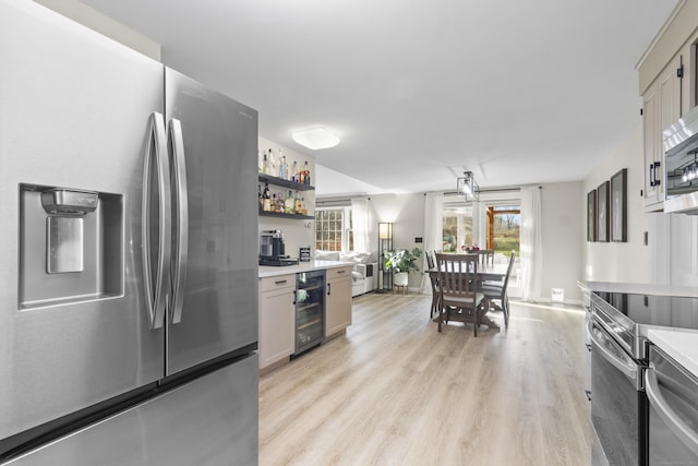 kitchen with wine cooler, stainless steel appliances, and light wood-type flooring