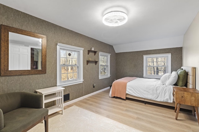 bedroom with lofted ceiling and light wood-type flooring