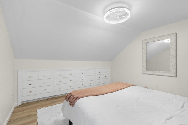 bedroom with light hardwood / wood-style flooring and vaulted ceiling