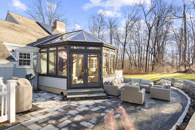 view of patio with a sunroom, an outdoor living space, and french doors