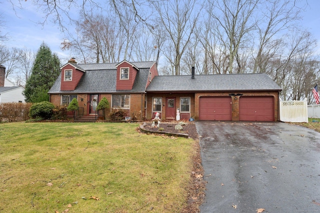 new england style home with a front yard and a garage