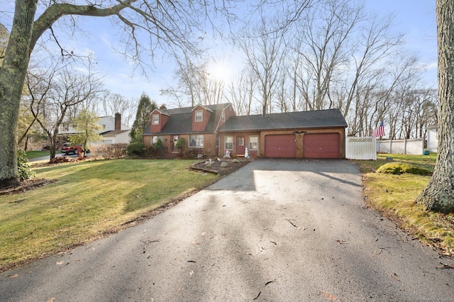 new england style home featuring a garage and a front yard