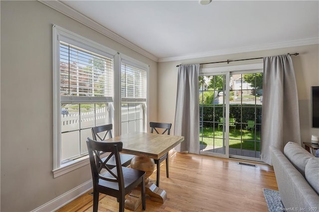 dining room featuring crown molding and light hardwood / wood-style floors