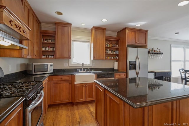 kitchen featuring a center island, sink, stainless steel appliances, light hardwood / wood-style flooring, and crown molding