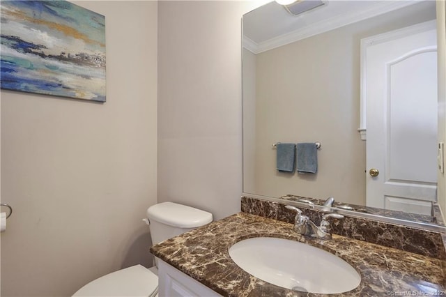 bathroom featuring vanity, toilet, and ornamental molding