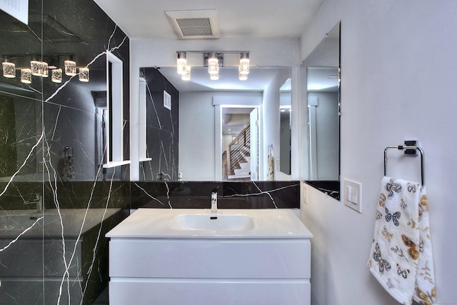 bathroom with vanity and tile walls