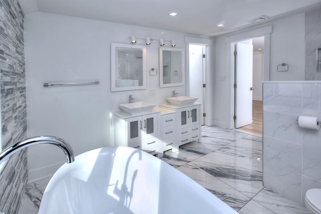 bathroom with vanity, toilet, and a tub