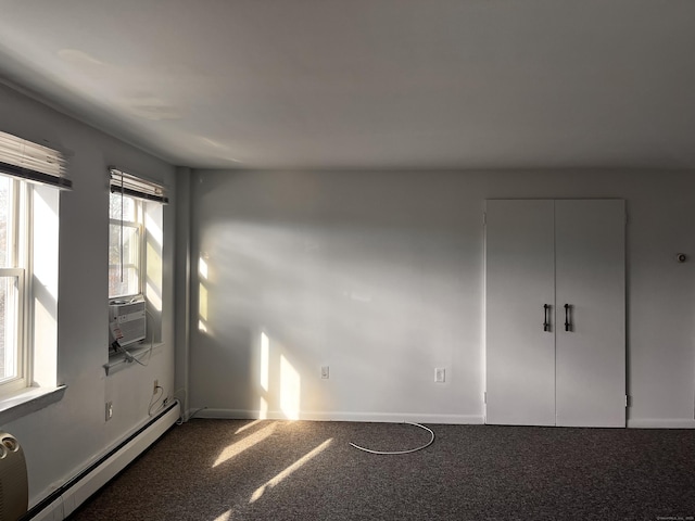 unfurnished bedroom featuring dark colored carpet, cooling unit, and baseboard heating